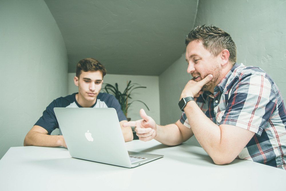 Tutor e estudante a trabalhar juntos num portátil